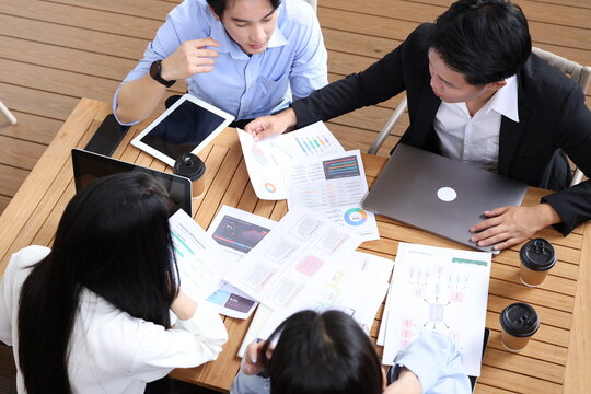 Business Professionals Collaborating on Financial Data Analysis at Outdoor Table