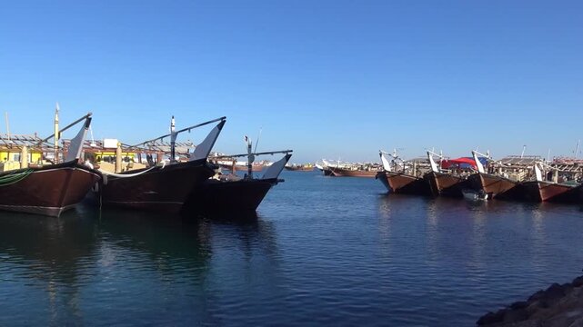 Traditional wooden dhow boats moored in the harbor of Sur, Oman