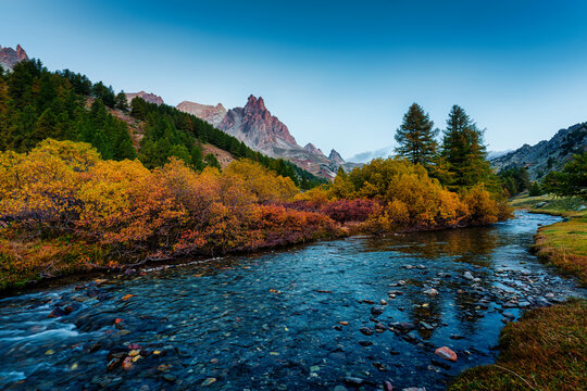 Rocky Mountain Peak over River Flowing Surrounded by Larch Forest in Claree Valley French Alps Nevache France