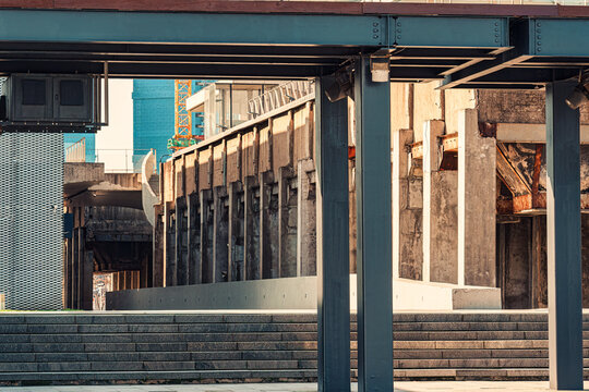 Industrial architecture framing concrete pillars and outdoor stone steps in urban city park