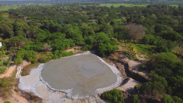 Aerial view of El Totumo mud volcano in Colombia with green tropical forest surroundings.