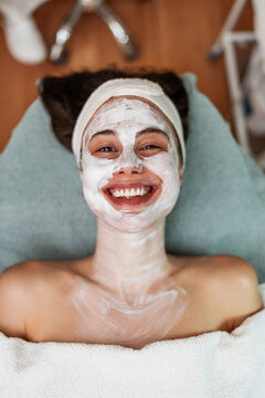 Rejuvenating skincare treatment session featuring a happy client lying down comfortably during a professional beauty procedure.