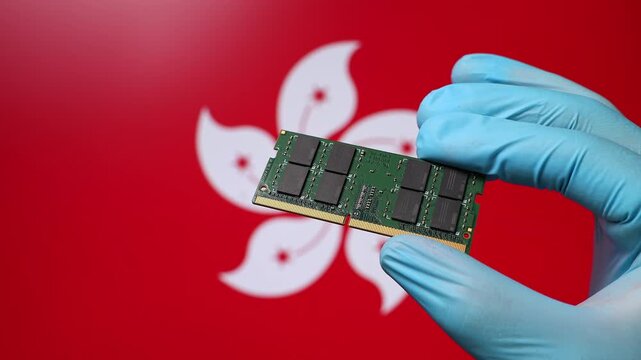 Close up view of hand in blue glove holding RAM memory microchip module. Hongkongese flag in blurred background. Concept of semiconductor shortage and artificial intelligence development in Hong Kong.