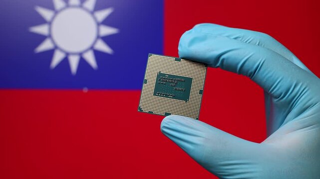 Close up view of hand in blue glove holding CPU microchip. Taiwanese flag in blurred background. Concept of semiconductor shortage and artificial intelligence development in Taiwan.