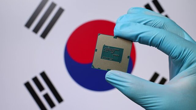 Close up view of hand in blue glove holding CPU microchip. South Korean flag in blurred background. Concept of semiconductor shortage and artificial intelligence development in South Korea.