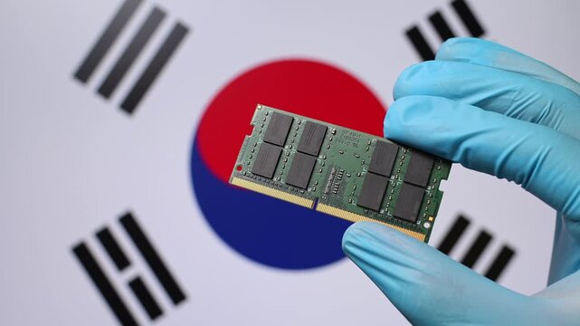 Close up view of hand in blue glove holding RAM memory microchip module. South Korean flag in blurred background. Concept of semiconductor shortage, artificial intelligence development in South Korea.