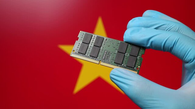 Close up view of hand in blue glove holding RAM memory microchip module. Vietnamese flag in blurred background. Concept of semiconductor shortage and artificial intelligence development in Vietnam.