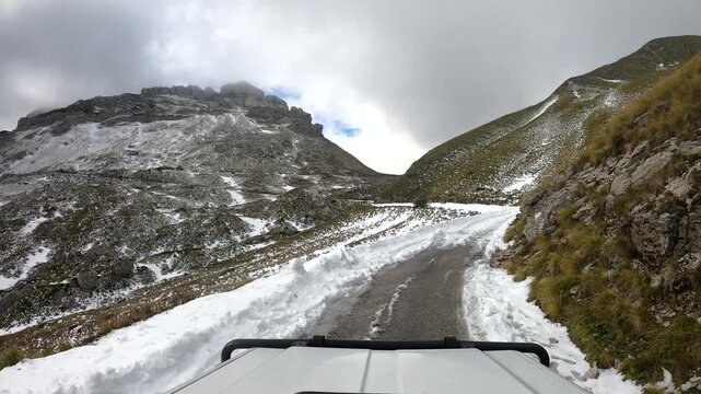 POV driving up a snowy road to Sedlo Pass that ends up being completely blocked by snow in Durmitor National Park rural Montenegro