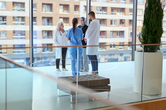 Medical team engages in discussion inside modern hospital during daylight hours