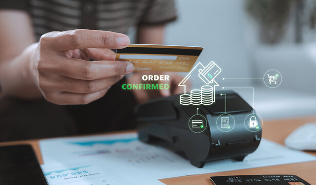 Real estate investment wealth planning payment concept financial advisor using credit card on POS terminal with virtual house coins and order confirmed hologram for property purchase