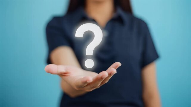 Close-up of a hand holding a glowing question mark icon, symbolizing inquiry, uncertainty, and problem-solving, with a subtle blue background and a medium shot panning effect.