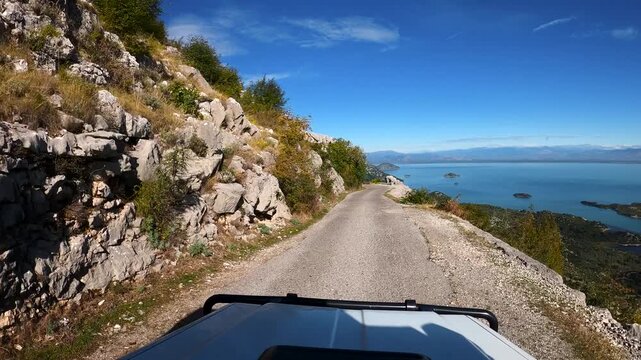 POV of a vehicle driving on a narrow road above Skadar Lake in the south of Montenegro