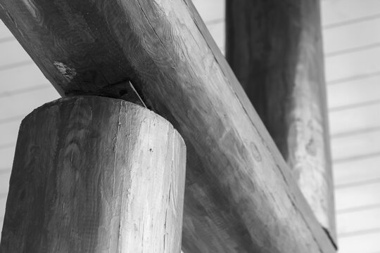 Gray wooden beams and round log columns supporting a paneled ceiling, abstract wooden architecture background photo