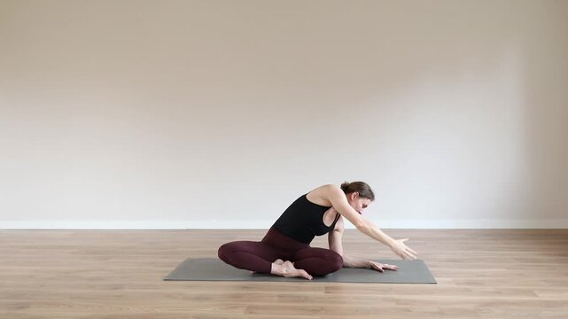 Woman practicing yoga in a modern yoga studio, focusing on balance, flexibility, mindfulness and relaxation in a peaceful wellness environment.