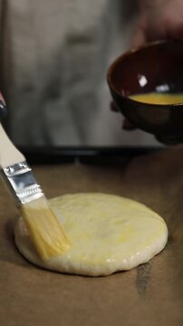 Woman preparing homemade burger buns in a kitchen, kneading and shaping fresh dough before baking.