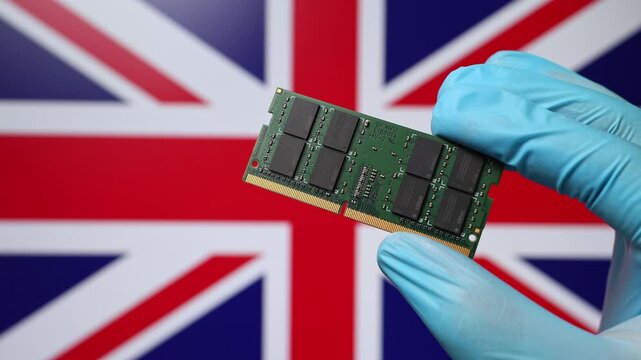 Close up view of hand in blue glove holding RAM memory microchip module. British flag in blurred background. Concept of semiconductor shortage, artificial intelligence development in United Kingdom.