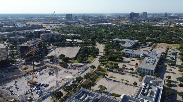 Photovoltaic solar grids cover commercial rooftops along Network Boulevard off Warren Parkway. Excavation pits neighbor paved parking fields within Hall Park corporate sectors, Frisco, Texas