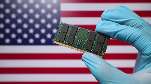 Close up view of hand in blue glove holding RAM memory microchip module. American flag in blurred background. Concept of semiconductor shortage and artificial intelligence development in USA.