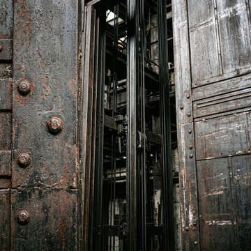 Extreme close-up of modern industrial elevators, minimalistic metal architecture, steel elevator cables and shaft details