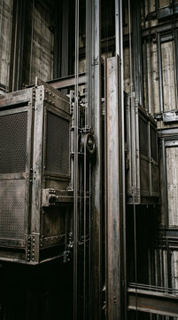 Extreme close-up of modern industrial elevators, minimalistic metal architecture, steel elevator cables and shaft details