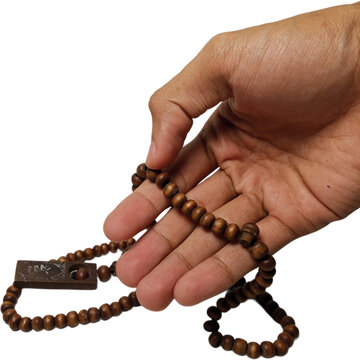 hand holding brown wooden prayer beads or tasbih