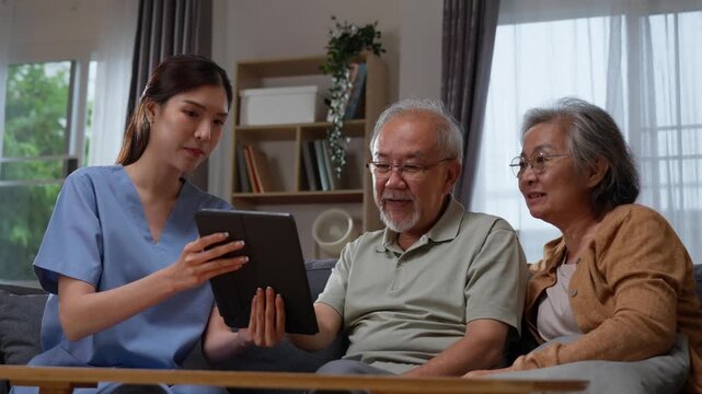 Female caregiver helping senior couple use digital tablet together at home.