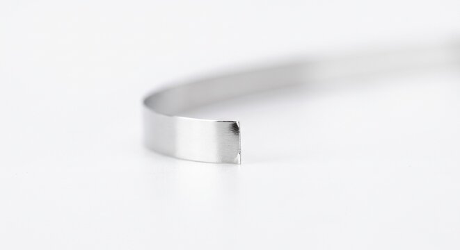Extreme macro of a solid-state battery lithium anode ribbon. Pure reflective metallic foil strip for advanced EV energy storage. Isolated on white.