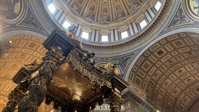 A vertical panning shot starting from the detailed, gilded coffered ceiling and moving down to reveal the St. Peter&rsquo;s Baldachin (Baldacchino di San Pietro) designed by Gian Lorenzo Bernini.