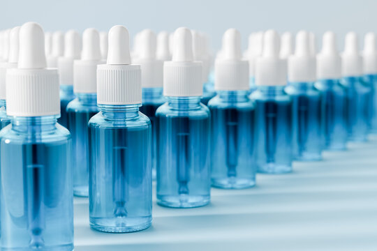 Blue glass dropper bottles filled hydrating facial serum. Cosmetic skincare concept featuring hyaluronic acid, active ingredients and professional dermatological treatment for healthy glowing skin.	
