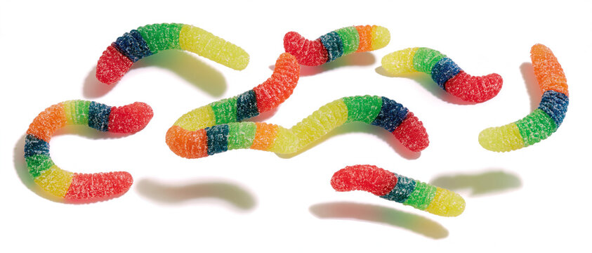 multicolored gummy worms floats scattered against a transparent background