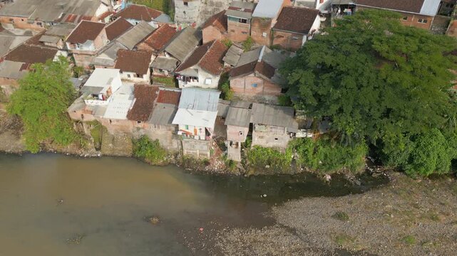 Poor Neighborhood Houses Built On The River Jember East Java Indonesia Drone Track Left 4K 60FPS