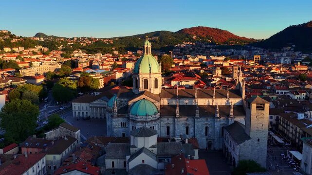 vacation in Como, historic town on lake Como in Italy, orbiting drone shot of Como cathedral at sunset in golden light, tourism in Italian lake Como