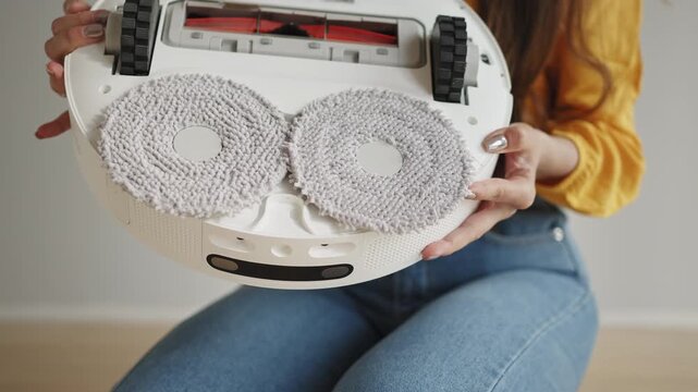 Person cleaning robot vacuum mop pads and brushes for optimal home cleaning performance