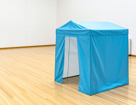 Blue privacy tent for an evacuation shelter standing on a wooden floor