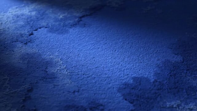 Dark blue textured surface with rough concrete wall pattern and soft side lighting