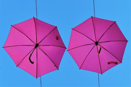 Vue de dessous de parapluies roses ouverts sous un fond de ciel bleu, symbolisant la lutte et la sensibilisation des femmes au d&eacute;pistage du cancer du sein