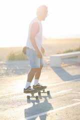 Skater practices tricks on a sunny day near the beach in the afternoon © KONSTANTIN SHISHKIN