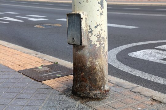 Dog urine damage of metal traffic light. City infrastructure problem. Corroded steel post in Benidorm, Spain.