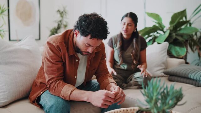 Stress, couple and conflict in home with argument, confrontation and separation of broken trust. Upset, people and jealousy on sofa for disagreement, insecurity and breakdown for infidelity suspicion