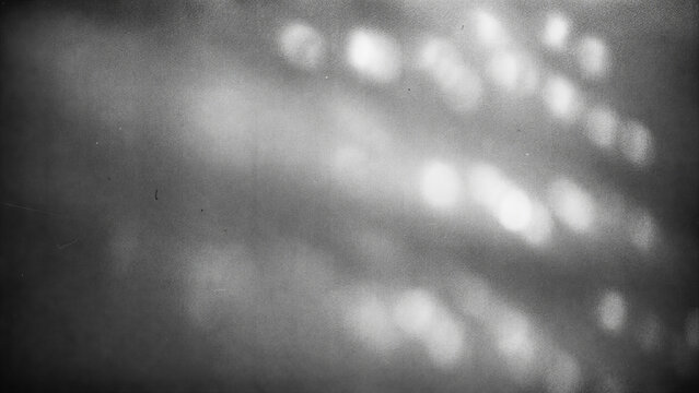 Abstract monochrome grainy bokeh light texture with blurred circles and scratched vintage analog film noise