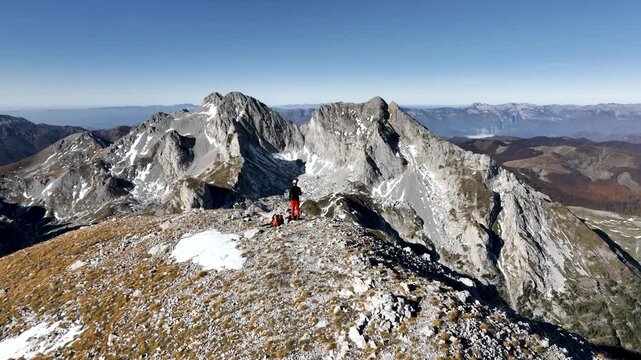 Aerial view of a hiker standing on top of Vasojevićki Kom in the Komovi mountain range in the south of Montenegro