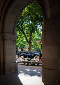 Blue 1914 Maxwell Model 35-4 vintage 100 years oldtimer car loaded on transport trailer viewed through old stone archway frame of town hall of Subotica, Serbia, Jul 4, 2026