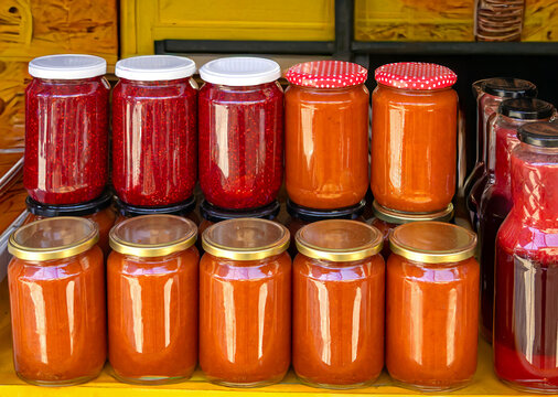 Homemade sweet fruit jams and other preserved spreads in glass jars sold on market