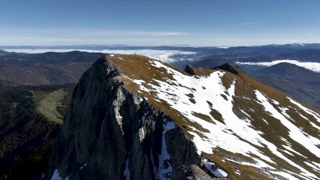 Aerial view of a hiker standing on top of Vasojevićki Kom in the Komovi mountain range in the south of Montenegro