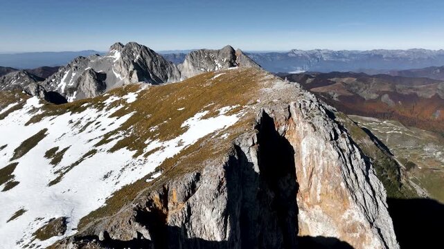Aerial view of a hiker standing on top of Vasojevićki Kom in the Komovi mountain range in the south of Montenegro