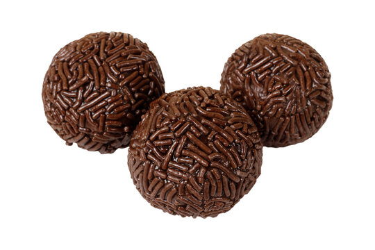 Three traditional Brazilian chocolate brigadeiros coated in sprinkles, isolated on a white background.