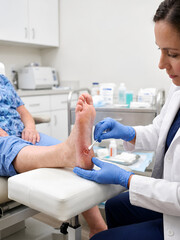 Obraz premium Medical professional examining and treating diabetic foot ulcer in clinical setting