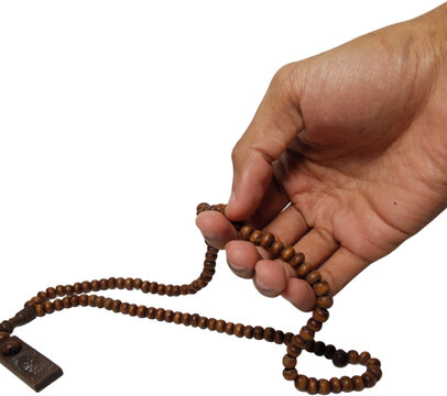 hand holding brown wooden prayer beads or tasbih