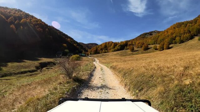 POV of an off-road vehicle driving on a gravel trail in the mountains of Montenegro