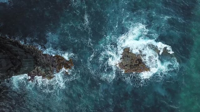 Slow drone drift across a lone sea stack circled by foam, background plate for travel edits, Sao Miguel, Azores